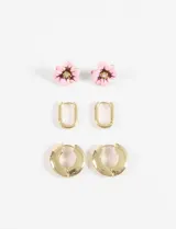 Set de tres pares de aros dorados: un par de caravanas con forma de flor esmaltada en rosa y centro con strass, un par de aros tipo eslabón alargado y un par de aros argolla gruesos.