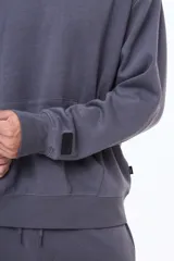 Buzo tipo canguro de felpa color gris, con capucha amplia, bolsillo frontal tipo canguro y puños acanalados.