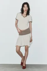 Falda mini de tiro bajo con cintura elástica ancha en color marrón y falda en color beige con bajo asimétrico.