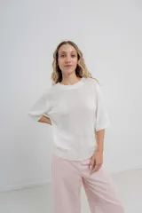 Buzo de punto liviano color blanco, con diseño oversize y mangas 3/4. Presenta cuello redondo, puños y ruedo con terminación acanalada.
