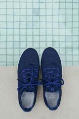 Zapatilla de diseño minimalista confeccionada en lana merino, con cordones al tono y suela de EVA. Presenta un estilo atemporal y versátil, ideal para uso diario.