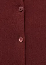 Cardigan de punto fino color bordó, con cuello redondo, cierre frontal de botones y manga larga. Diseño recto y entallado.