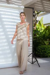 Pantalón de corte sastrero con cintura alta, pinzas delanteras y pierna ancha de caída fluida.