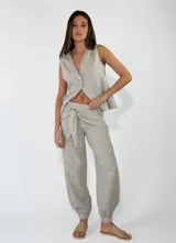 Pantalón de lino color rojo, de corte holgado con botamangas elastizadas y diseño cruzado en la cintura con lazo ajustable.