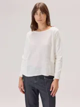 Remera de manga larga con diseño de paneles combinados. Presenta un panel frontal central de lino con textura visible y mangas y paneles laterales de viscosa con elastano. Posee cuello redondo y costuras decorativas en contraste.