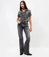 Pantalón de jean con corte flare, tiro medio y efecto desgastado. Presenta cierre frontal con botón, pasantes para cinturón y bolsillos traseros con solapa.