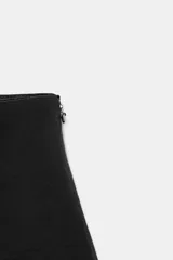 Falda pantalón de tiro medio con bajo acabado en volantes y cierre lateral con cremallera oculta.