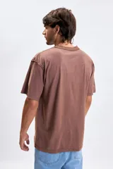 Remera de manga corta con corte oversize, color marrón con efecto lavado. Presenta una estampa frontal con la frase 'true real ones here' en letras pequeñas y tono sobre tono.