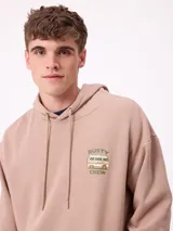 Canguro negro con capucha y estampado grande en la espalda de un paisaje con árboles, una camioneta camper y un lago al atardecer, con el logo "RUSTY" en la parte superior.