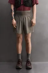 Short deportivo de trail running confeccionado en tejido técnico elástico con textura. Presenta una cintura elástica ancha con compartimentos integrados, bolsillo trasero con cierre y aberturas laterales en el bajo.