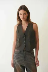 Chaleco de denim con proceso de encerado, escote en V y cierre frontal con botones. Presenta dos bolsillos laterales con solapa y un diseño bitono con efecto desgastado.