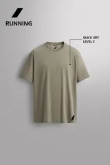 Camiseta de entrenamiento regular fit color beige, confeccionada en combinación de tejidos técnicos ligeros y elásticos con tecnología Quick Dry nivel 2. Presenta cuello redondo, manga corta, acabados con costuras planas y termofijadas, y detalle de logo estampado en el bajo.