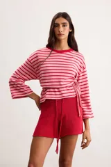 Remerón de algodón a rayas horizontales celestes y rojas, con silueta oversize, cuello redondo y mangas 3/4.