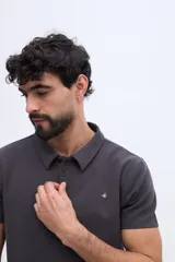 Remera polo verde militar con textura sutil, de manga corta, cuello camisero y cierre frontal de botones.