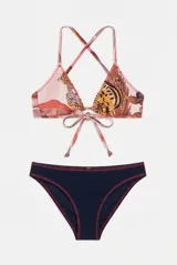 Conjunto de bikini compuesto por un top triangular con tirantes cruzados en la espalda y nudo frontal, con estampado de animales, y una bombacha azul marino de textura acanalada con costuras rojas a contratono.
