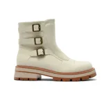 Bota de caña media color beige, confeccionada en material tipo gamuza, con suela track de goma en tono terracota y tres correas laterales con hebillas metálicas decorativas.