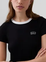 Remera corta de ajuste ceñido color blanco con cuello redondo y ribete negro. Presenta mangas cortas y el logo bordado de Gap en el pecho.