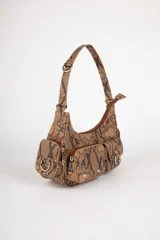 Cartera negra de símil cuero con asa corta fija y cuatro bolsillos externos con tachas y hebillas metálicas.