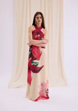 Vestido largo fluido de gasa color crudo con estampa floral en tonos rojos y fucsias, con escote halter cruzado de cuero.