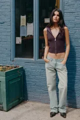 Top de punto canalé en color bordó, sin mangas y con cuello alto. Presenta un cierre frontal completo con cremallera metálica.