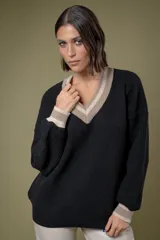 Buzo de punto en lambswool, color negro, con escote en V y detalles de rayas en contraste color beige en el cuello y los puños. Presenta un diseño holgado de manga larga.