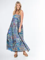 Vestido largo de algodón con estampado multicolor, corte cuadrado y elástico en la espalda. Incluye un aplique de flor desmontable.