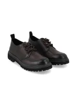 Zapato de cuero marrón oscuro con cordones, suela track robusta y costuras pespunteadas visibles alrededor de la base.
