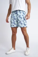 Short de baño con cintura elástica y cordón ajustable, confeccionado en tela ligera de secado rápido. Presenta un estampado botánico integral en tonos amarillos, blancos y azules, con dos bolsillos delanteros y uno posterior.