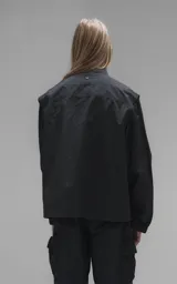 Chaqueta técnica liviana de microfibra con acabado mate, diseño con mangas desmontables que permiten convertirla en chaleco. Cuenta con cuello tipo camisa, cierre frontal oculto, cuatro bolsillos frontales de gran tamaño y puños elásticos. Incluye logo bordado en relieve en el pecho.