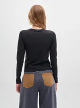 Remera de manga larga con cuello a la base, confeccionada en tejido acanalado con calce al cuerpo y diseño tipo crop.