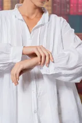 Camisa blanca de algodón con corte amplio, tablitas en la parte delantera y volados en el cuello.