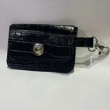 Tarjetero pequeño negro con textura de cocodrilo, cierre con broche metálico y gancho metálico para colgar.