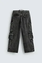Pantalón cargo de denim lavado negro, corte relajado y tiro medio. Presenta múltiples bolsillos cargo con solapa y detalle de cierre en las perneras, además de bolsillos de vivo traseros. El bajo es ajustable con trabilla.