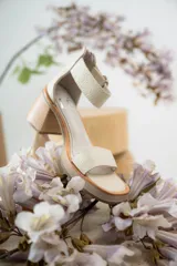 Sandalias de cuero color beige con plataforma y taco cuadrado de madera. Presentan una tira frontal ancha y una tira ajustable en el tobillo con hebilla metálica plateada.