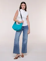 Cartera bandolera de lona naranja en forma de medialuna, con correa ajustable negra y cierre principal.