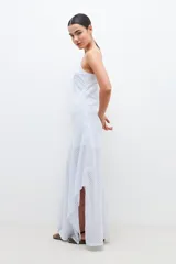 Maxi vestido celeste con rayas verticales blancas y plateadas, breteles finos y corte al bies.