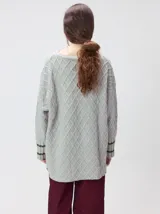 Sweater gris de punto con diseño de rombos, cuello redondo y mangas largas. Cuenta con puños largos acanalados con rayas horizontales en color verde militar y un pequeño logo bordado en el pecho.