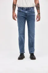 Jean de corte slim, ajustado desde la cadera hasta los tobillos, en color azul medio con acabado clásico.