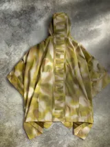 Poncho impermeable Columbia de edición especial inspirada en Star Wars, con diseño camuflado en tonos verde y beige, cierre frontal parcial con cremallera, capucha ajustable y cinturón integrado. Cuenta con la insignia de la Alianza Rebelde.
