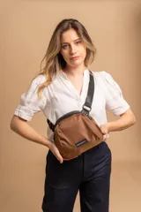 Bandolera pequeña de diseño moderno, confeccionada en tafeta liviana y resistente. Cuenta con cierre superior, correa ancha ajustable y logo frontal de la marca.