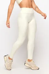 Calza larga deportiva de tiro alto en color marfil, confeccionada en tejido elástico con costuras drapeadas que realzan la figura.