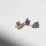 Par de aros dorados con pasante y fru fru. De cristales lavanda en forma de lágrima, engarzados en acero con baño de oro de 18k.