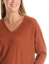 Buzo de tejido fino con escote en V, mangas tres cuartos estilo dolman y corte holgado.