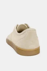 Zapatillas tipo deportiva confeccionadas en serraje color beige, con diseño barefoot de puntera amplia, suela flexible efecto engomado y cierre mediante cordones al tono.