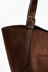 Bolso shopper marrón con acabado cepillado suave, asas ajustables de cuero con hebilla metálica, cierre de mosquetón y compartimento interior con cierre.