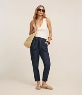 Pantalón baggy de jean azul oscuro, de tiro alto con cintura elástica fruncida y lazo para ajuste. Presenta bolsillos laterales y dobladillos con vuelta en los tobillos.