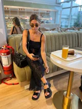 Top de encaje negro con breteles finos y escote con abertura.