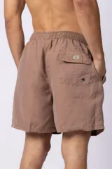 Short de baño de corte clásico con cintura elástica y cordón ajustable. Presenta un acabado efecto lavado vintage, bolsillos laterales y un pequeño logo bordado en la parte inferior.