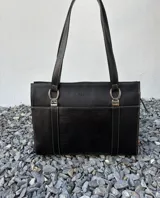 Cartera tipo shopper de cuero genuino marrón con panel central de textura símil cocodrilo y herrajes metálicos plateados.