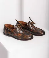 Mocasines de cuero color marrón óxido con cordones y costuras pespunteadas en rojo.